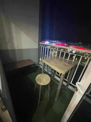 a table and stool on a balcony at night at Kys 3 staycation near NAIA mall of asia in Manila