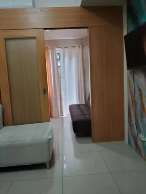 a living room with a couch and a chair and a tv at Kys 4 staycation mall of asia in Manila