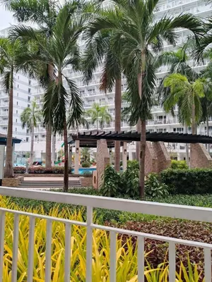 a white fence with palm trees in front of a building at Kys 4 staycation mall of asia in Manila