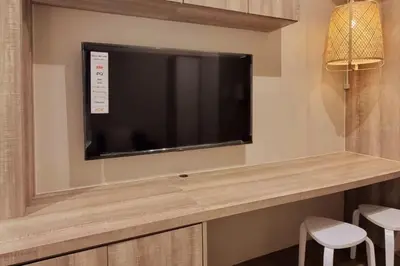 a flat screen tv on a wall in a room at Cosmopolitan Comfort Makati 1 BR Wonder 300MB 2428 Internet in Manila
