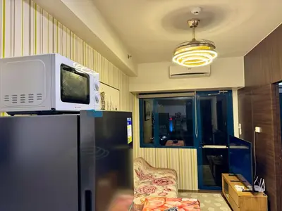 a microwave on top of a refrigerator in a room at 3 Bedroom Air condo Pool Perfect Holiday Gym Swim 300 Mbps in Manila
