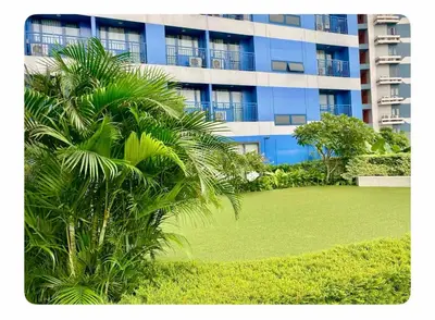 a palm tree in front of a large building at Chic Luxury Air condo 2 Bedroom Finest City Living Air Makati Gym Swim Park 300 in Manila
