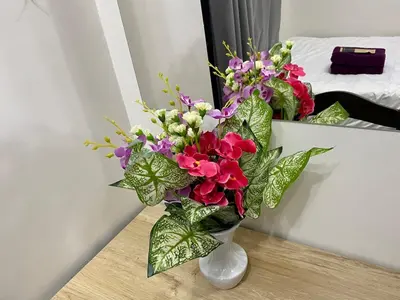 a vase filled with flowers sitting on a table at Cruise Ship Condo Escape Makati 300 Mbps Gym Swim Park 2271 in Manila
