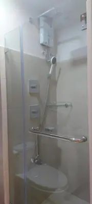 a bathroom with a glass shower with a toilet at Dahl's Cozy Place in Manila