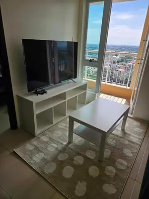 a living room with a table and a large window at 3BR at The Rochester in Manila