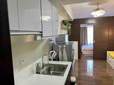 a kitchen with a sink and a kitchen with a bed at Cosmo Nest Air Skyline One BR Makati 2270 Gym Swim Park 300 Mbps in Manila
