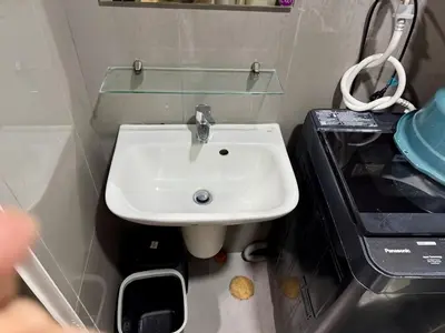 a bathroom with a sink and a glass shelf at Galloping Suite Executive Makati Suite Gym Swim Park 300 Mbps in Manila