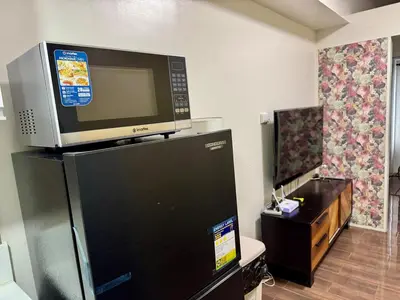 a television on top of a refrigerator in a room at Galloping Suite Executive Makati Suite Gym Swim Park 300 Mbps in Manila