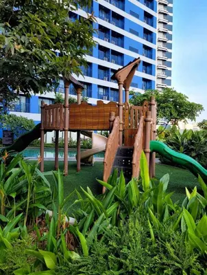 a playground in front of a tall building at Jazz Air Rooftop Penthouse Bar Gym Swim Park 300 Mbps Air 4034 in Manila