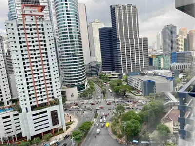a city with a busy street with traffic in the city at Makati Broadway Bliss Golden spot Gym Swim Park 300 Mbps 1940 in Manila
