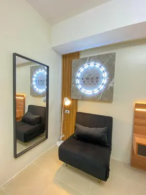 a living room with a mirror and a chair at cozy studio unit near airport in Manila
