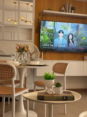 a dining room with a tv and a table and chairs at Chic Staycation with Balcony,few step in venice mall in Manila