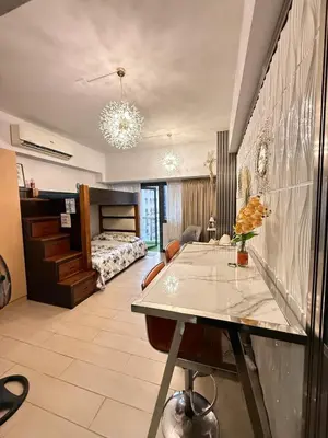 a living room with a table and a bedroom at Luxurious Studio Unit in Salcedo in Manila