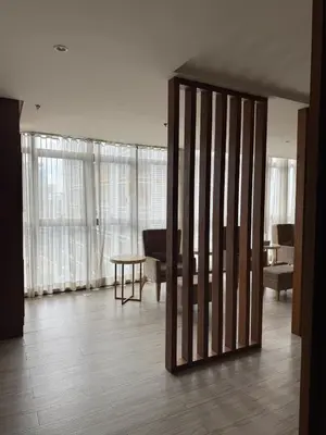 a living room with a partition with a table and a piano at Luxurious Studio Unit in Salcedo in Manila