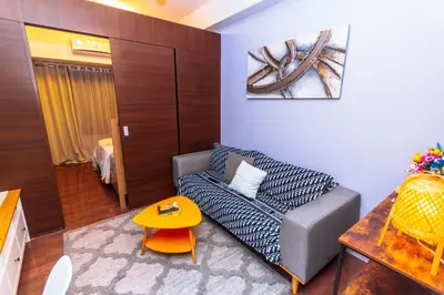 a living room with a couch and a table at Chic Floating Penthouse Makati Gym Air condo gym swim park 300MB in Manila