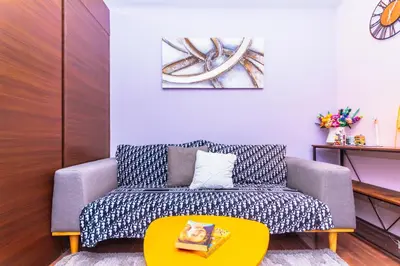 a living room with a couch and a yellow table at Chic Floating Penthouse Makati Gym Air condo gym swim park 300MB in Manila