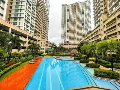 a large swimming pool in a city with tall buildings at Studio condo near Pobla Makati in Manila