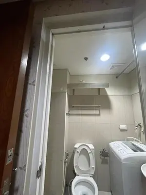 a small bathroom with a toilet and a sink at Shell residence moa in Manila