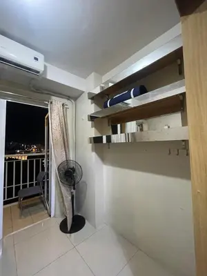 a room with a balcony with a fan and a window at Shell residence moa in Manila