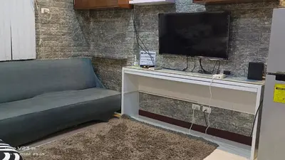 a living room with a couch and a flat screen tv at Nethcondo in Manila