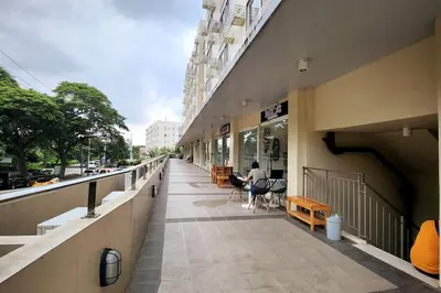 a corridor of a building with a person sitting on a bench at TheMudroomStyle ideal WFH near St Benedict Parish in Silang