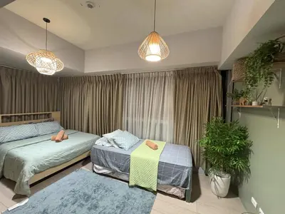 a bedroom with two beds and a window at Cozy 3 Bedroom in Uptown Parksuites - Near Mall, Restaurants and Supermarket in Manila
