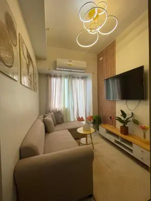 a living room with a couch and a flat screen tv at Filed Residences Hotel Apartment in Manila