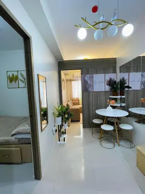 a room with a table and chairs and a bed at Filed Residences Hotel Apartment in Manila