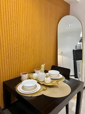a dining room table with plates and dishes on it at ElixirStaycation at Knightsbridge Residences in Manila