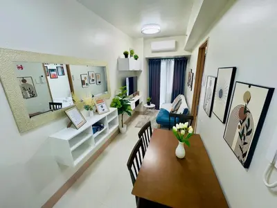 a living room with a table and a blue chair at Luxurious Condo Near SM MOA in Manila