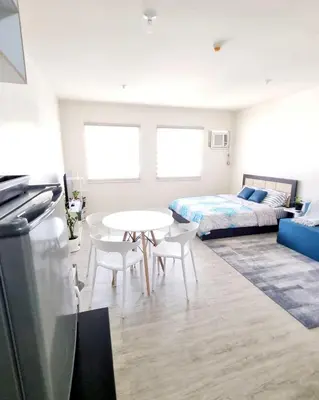 a living room with a bed and a table and chairs at Joms Minimalist Crib Nuvali in Calamba