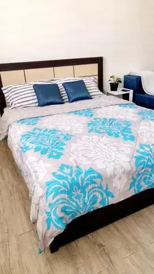 a bed with blue and white sheets and blue pillows at Joms Minimalist Crib Nuvali in Calamba