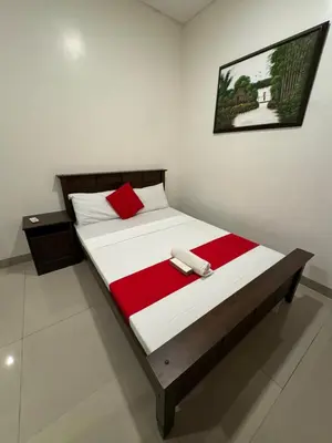 a bedroom with a large bed with a red blanket at Casa Maria by Juemarst Suites in Manila