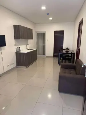 a large living room with a couch and a kitchen at Casa Maria by Juemarst Suites in Manila