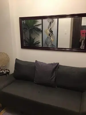 a couch in a living room with a mirror at 1BR with balcony Condotel in MOA Complex, Entertainment City, near NAIA, free wifi, netflix in Manila