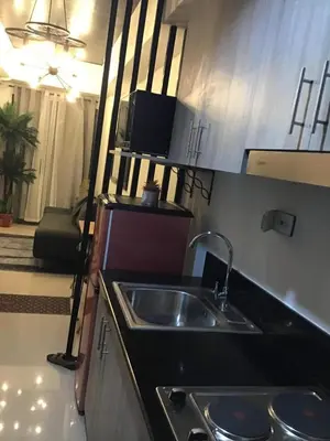 a small kitchen with a sink and a microwave at 1BR with balcony Condotel in MOA Complex, Entertainment City, near NAIA, free wifi, netflix in Manila
