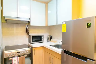 a kitchen with a stainless steel refrigerator and a microwave at Avant Apartments at The Fort in Manila