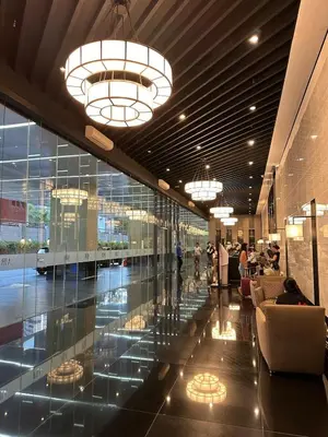a lobby with glass walls and chandeliers in a building at 1BR Air Residences condo, Ayala Ave, Makati in Manila