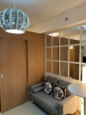 a living room with a couch and a chandelier at 1BR Ayala Makati Apartment at Lush Residences in Manila
