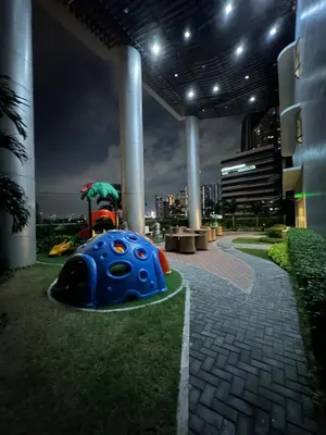 a playground in a building at night with a city at 1BR Ayala Makati Apartment at Lush Residences in Manila