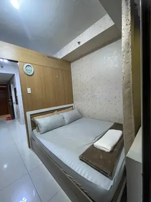 a small bed in a room with a clock on the wall at 10hrs stay in Manila