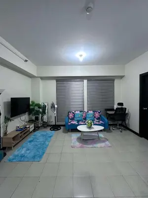 a living room with a blue couch and a table at Phebestaycation in Manila
