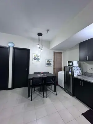a kitchen with a black table and a black refrigerator at Phebestaycation in Manila