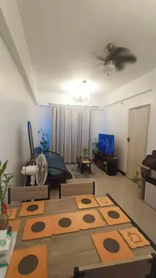 a living room with a rug on the floor at Casa Broganza in Manila