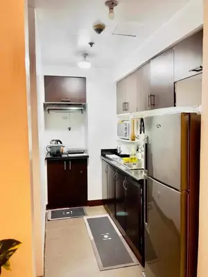 a small kitchen with a stainless steel refrigerator at Casa Broganza in Manila