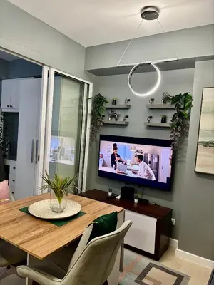 a dining room with a table and a tv at Casa Valentine - Azure Urban Resorts Residences in Manila