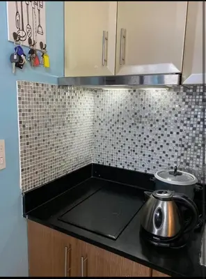 a kitchen counter top with a tea pot on a stove at One Palm Tree Villas Near NAIA terminal 3 in Manila