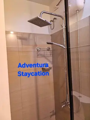a bathroom with a shower with a shower head at Adventura Staycation in Manila