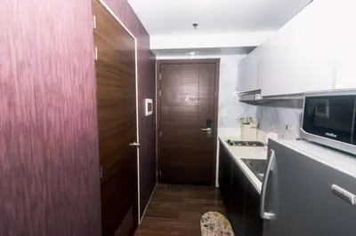 a small kitchen with a wooden door and a kitchen counter at Air residence Snuggle in Style 1 BR condo Makati swim gym park surf 300 Mb in Manila