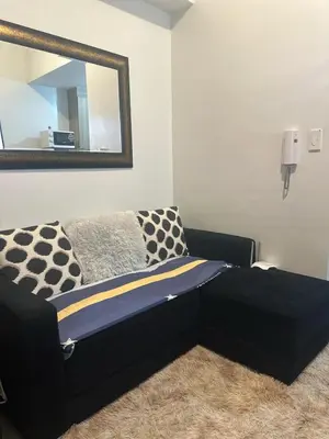 a black bed in a room with a mirror at Jaja staycation in Manila